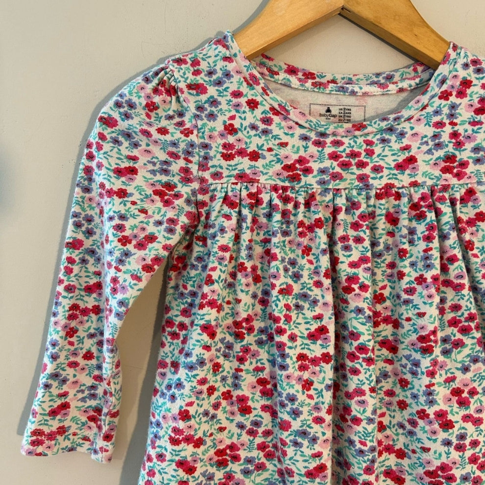 Close-up detail of Baby Gap white long-sleeve top showing ditsy floral print in red purple and pink with gathered yoke for girls 18M