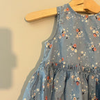 Close-up detail of H&M dusty blue dress showing floral pattern with bunny print and gathered elastic waist