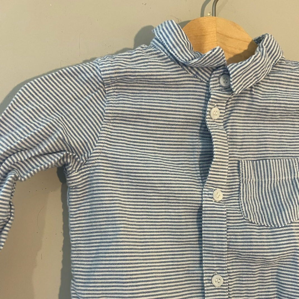 Close-up detail of H&M blue and white striped baby boys shirt showing collar buttons and chest pocket stitching size 6-12 months