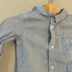 Close-up detail of H&M blue and white striped baby boys shirt showing collar buttons and chest pocket stitching size 6-12 months