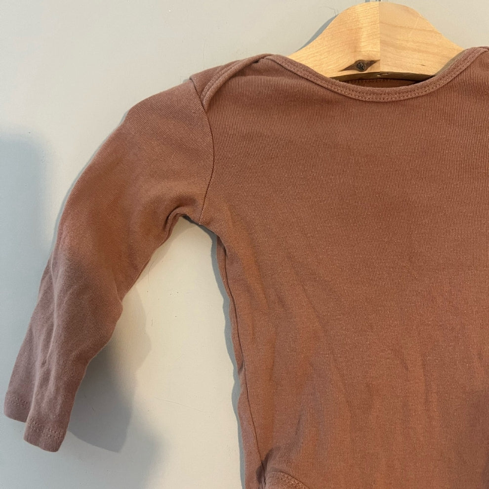 Close-up detail of H&M mocha brown ribbed long-sleeve baby bodysuit showing soft ribbed cotton fabric and shoulder stitching size 6-12 months