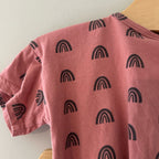 Close-up detail of Indy + Pippa mauve cotton tee showing bold all-over black rainbow print pattern for girls 9-12 months