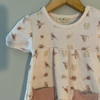 Close-up detail of Kit + Pearl dress neckline showing bird and rainbow print on organic cotton