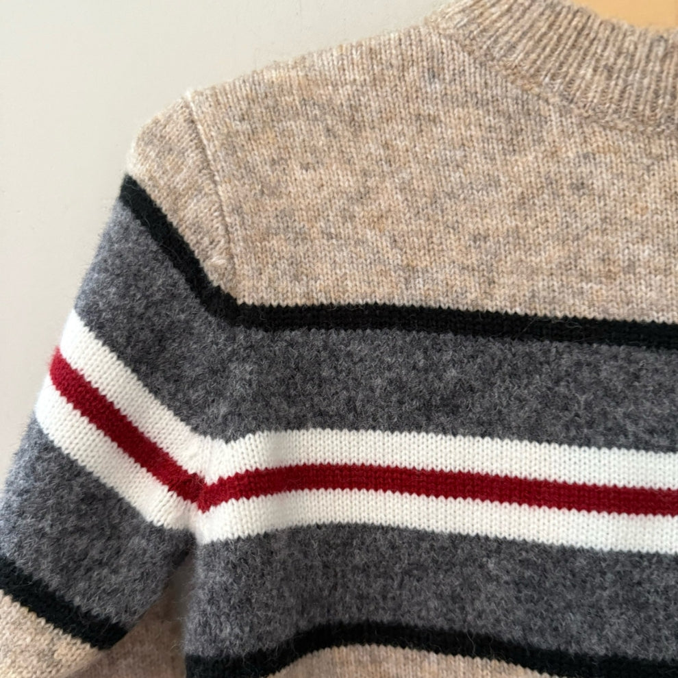 Close-up detail of Mayoral beige wool-blend sweater showing charcoal gray color-block with black white and red stripe pattern for boys 5Y