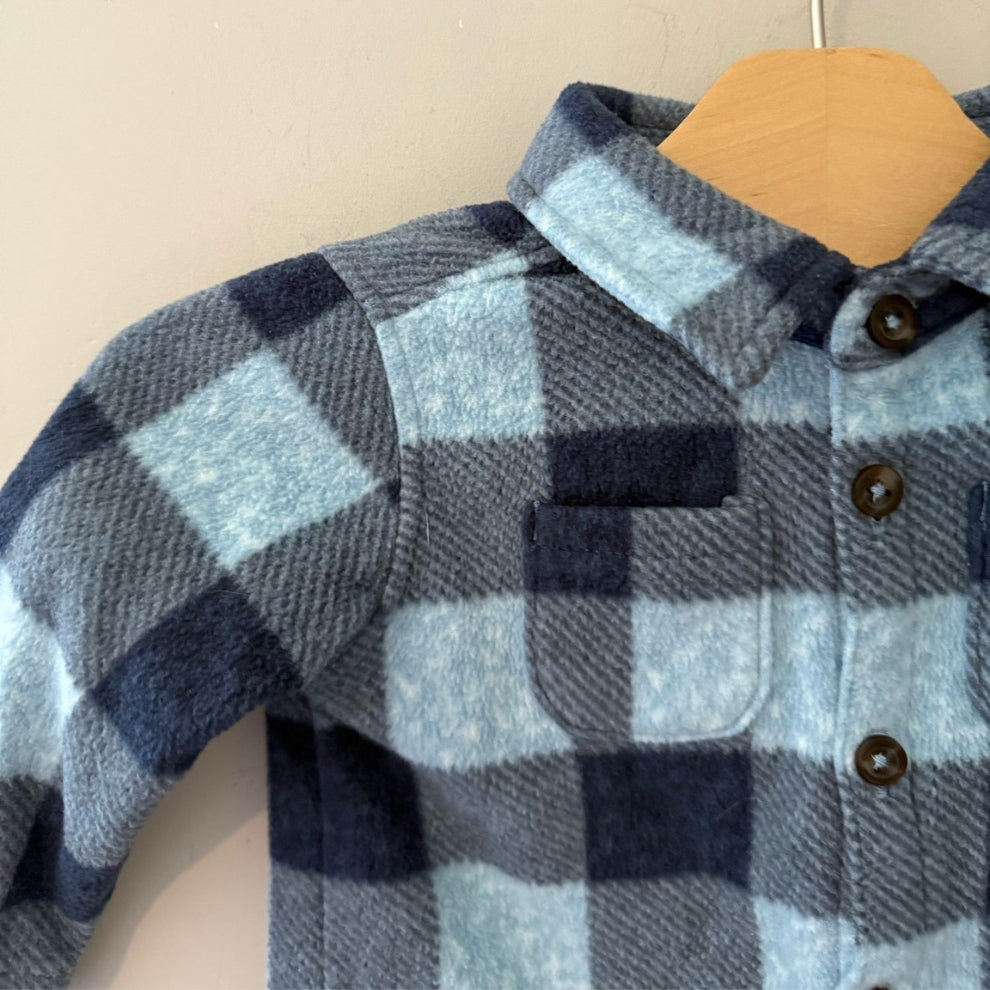 Close-up detail of Old Navy blue buffalo plaid fleece shacket showing chest pocket, dark buttons and collar for boys 6-12 months