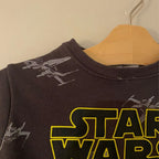 Close-up of Zara black sweatshirt showing Star Wars logo and X-Wing starfighter graphic detail