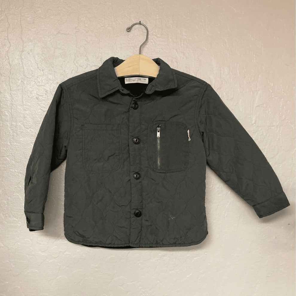 Front view of Zara boys' puffer jacket in charcoal with button closure and zipper pocket detail