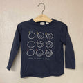 Close-up of Zara navy blue tee featuring how to draw a face graphic tutorial with numbered steps