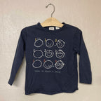 Close-up of Zara navy blue tee featuring how to draw a face graphic tutorial with numbered steps